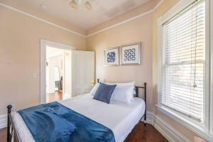 een slaapkamer met een bed met een blauwe deken erop bij A+ 2 BR Victorian Home away from Home in Sacramento