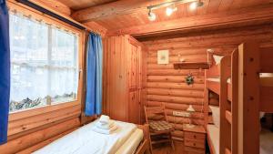 ein Bad mit einem Bett, einer Badewanne und einem Fenster in der Unterkunft Blockhaus A in der Ziegelwies in Füssen