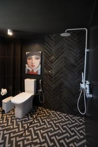 baño con aseo y una pintura en la pared en City's Best-Kept Secret, Eclectic & Luxe Getaway, en Kalamata