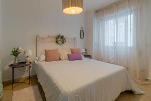 een slaapkamer met een groot wit bed en een raam bij Apartamento Céntrico Isaura in Córdoba