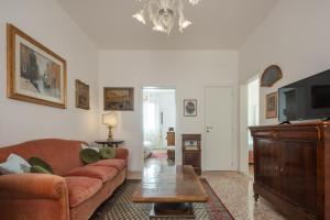 Una sala de estar con un sofá y un televisor. en Tiepolo Apartment in the Biennale District R&R, en Venecia