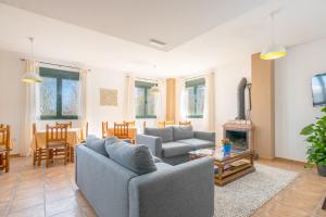 a living room with two couches and a fireplace at Hotel Rural El Castillejo in Cuevas del Becerro