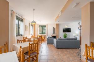 ein Wohnzimmer mit einem Sofa, einem Tisch und Stühlen in der Unterkunft Hotel Rural El Castillejo in Cuevas del Becerro