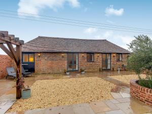 a brick house with a patio in front of it at The Stables - Uk41887 in Peasmarsh