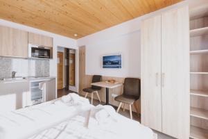 sypialnia z łóżkiem, stołem i krzesłami w obiekcie Appartements Sulzer by we rent, SUMMERCARD INCLUDED w mieście Zell am See