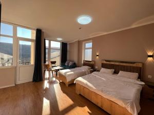 sypialnia z 2 łóżkami i dużym oknem w obiekcie Ahval Hotel w mieście Qusar