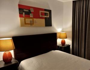 Una habitación de hotel con una cama y dos lámparas. en Ares do Mar - 4 beds apartment and car parking, en Matosinhos