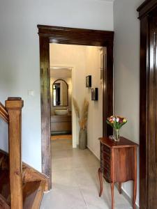 un pasillo con espejo y una mesa con flores. en Maisonette Lucia Traditional House Prime Location, en Pireo