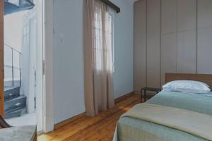 sypialnia z łóżkiem i telewizorem w obiekcie Maisonette Lucia Traditional House Prime Location w Pireusie
