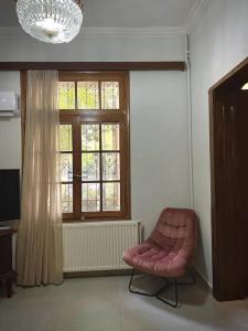 una camera con una sedia rosa e una finestra di Maisonette Lucia Traditional House Prime Location a Pireo