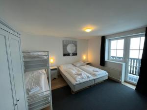 ein Schlafzimmer mit einem Bett und einem Etagenbett in der Unterkunft Alpenhof by AlpenTravel in Bad Gastein
