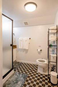 Baño con aseo y toallas en la pared en *2bdr Victorian Home away from Home - *Central Loc en Sacramento