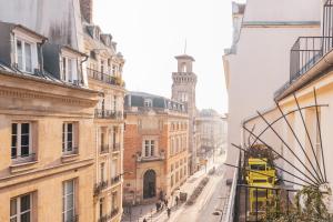 a city street with buildings and a clock tower at Hotel Le petit Paris in Paris