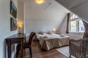 a bedroom with two beds and a table and a window at Hotel Breeburg in Bergen