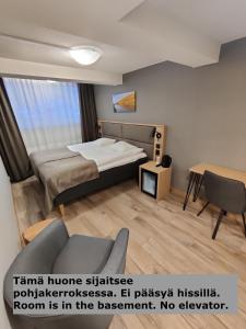 Habitación de hotel con cama y sofá en Hotelli Toivola, en Kemi