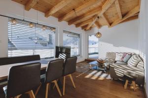 a dining room with a table and chairs and a couch at Appartements Sulzer by we rent, SUMMERCARD INCLUDED in Zell am See