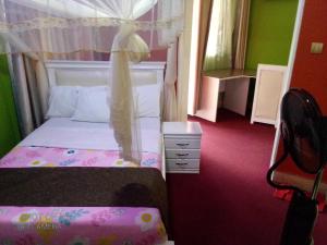 a small bedroom with a bed with a canopy at Bethel Resort & Hotels in Gulu
