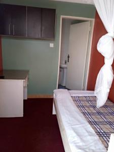 um quarto de hotel com uma cama e uma casa de banho em Bethel Resort & Hotels em Gulu