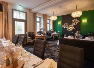 ein Esszimmer mit Tischen und Stühlen und grünen Wänden in der Unterkunft Hotel Via Regia - VIAs-Hotels in Görlitz