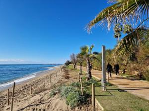 personas caminando por la playa en un día soleado en Villa Costa Marbella en Marbella