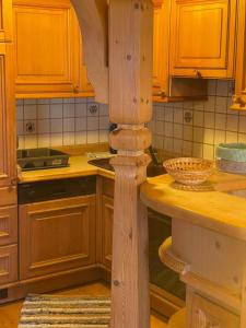 a kitchen with wooden cabinets and a wooden column at Hotel Sonnleiten in Reit im Winkl