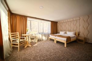um quarto com uma cama, uma mesa e cadeiras em Kompozitor Hotel Dilijan em Dilijan