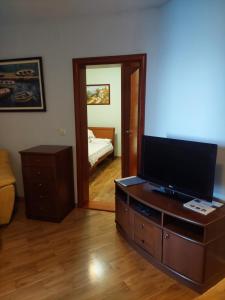 a living room with a flat screen tv on a dresser at Plava Vila Beach Apartments Sveti Stefan in Sveti Stefan