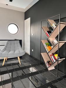 ein Zimmer mit einer Bank und einem Bücherregal in der Unterkunft Luxueuse propriété SAINT CIRICE aux vues aériennes in Cahors