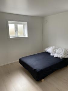 a bed in a white room with a window at Hus m gaard have, 25m fra havet, havn, Strand, High speet internet, restauranter in Rungsted