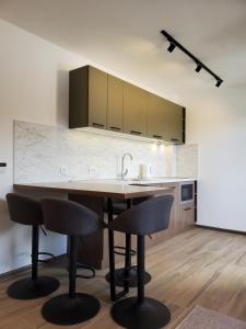 une cuisine avec une table, des chaises et un évier dans l'établissement Apartman Green - Ravna planina, à Pale 15 autres photos