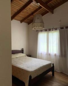 塞拉利昂德洛斯教士的住宿－Puerto Paraíso，一间卧室配有一张带吊灯和窗户的床。