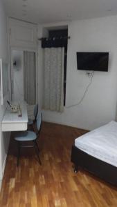 ein Schlafzimmer mit einem Bett und einem Schreibtisch sowie einem Bett, einem Tisch und einem Stuhl in der Unterkunft Flat na 16 de março, centro Historico de Petropolis in Petrópolis