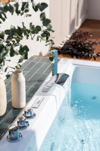 una piscina con una mesa con tazas y una planta en Magno Apartments Robles with Bath Tub and Private Parking en Sevilla