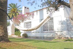 una casa blanca con una hamaca delante en Charming seafront villa, en Cambrils