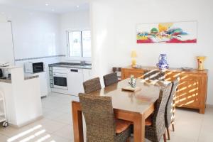 cocina y comedor con mesa de madera y sillas en Charming seafront villa, en Cambrils