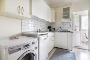 eine weiße Küche mit Waschmaschine und Trockner in der Unterkunft Modern Flat with Balcony on Bagdat Street in Istanbul