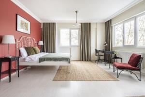Schlafzimmer mit roten Wänden, einem Bett und einem Schreibtisch in der Unterkunft Modern Flat with Balcony on Bagdat Street in Istanbul