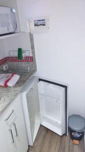 eine Küche mit einer weißen Theke und einem weißen Kühlschrank in der Unterkunft Flat na 16 de março, centro Historico de Petropolis in Petrópolis