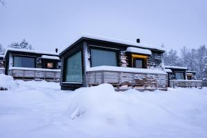 a cabin in the snow with snow around it at Holiday Village Inari in Inari