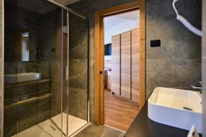 un bagno con doccia in vetro e lavandino di Hotel Rio a Caderzone Altre 37 foto