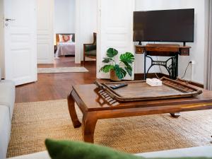 een woonkamer met een salontafel en een flatscreen-tv bij The Arcade in Athene