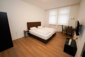 Dormitorio con cama, escritorio y TV en Design Apartments 2, en Dortmund