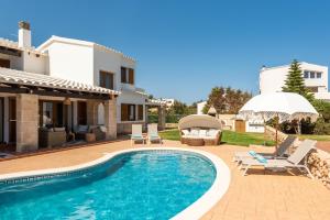 a villa with a swimming pool and a house at Lasaienea 4 bedroom villa, Cala Morell in Cala Morell
