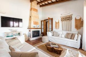 a living room with a white couch and a fireplace at Lasaienea 4 bedroom villa, Cala Morell in Cala Morell