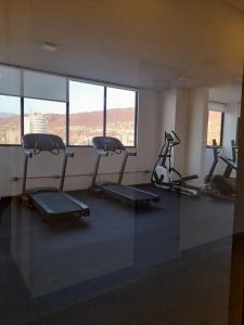 un gimnasio con varias bicicletas estáticas en una sala con ventanas en Central vista al mar, en Antofagasta