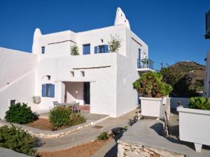 una casa blanca con plantas delante en Nola Traditional Villa with pool and amazing sea views, Paros, en Kampos