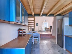 cocina con armarios azules y comedor en Nola Traditional Villa with pool and amazing sea views, Paros, en Kampos