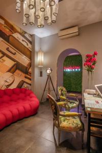 a living room with a red couch and a table at Navona Colors Hotel in Rome