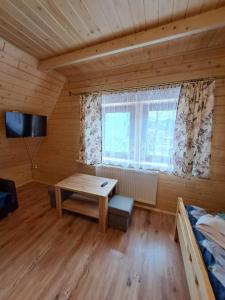 een kamer met een tafel, een bed en een raam bij Dworek na skraju lasu in Kościelisko
