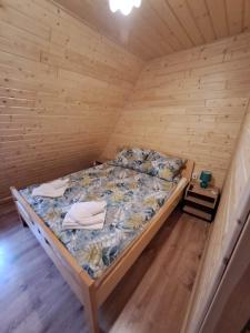 een slaapkamer met een bed in een houten kamer bij Dworek na skraju lasu in Kościelisko